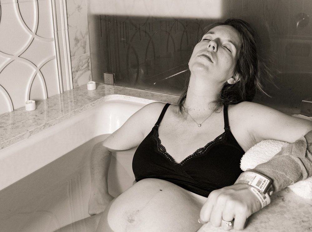 Maddy laboring in the tub during the birth of her first daughter